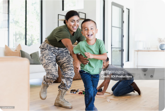 Image of woman in military uniform chasing after a child, playfully