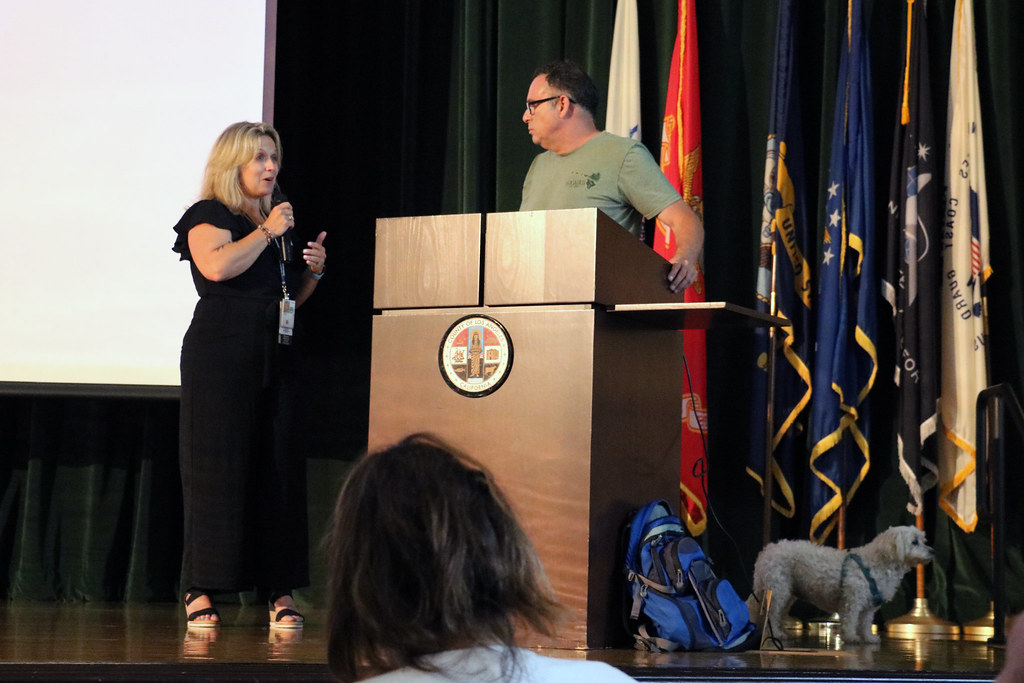 Woman speaking with man at podium