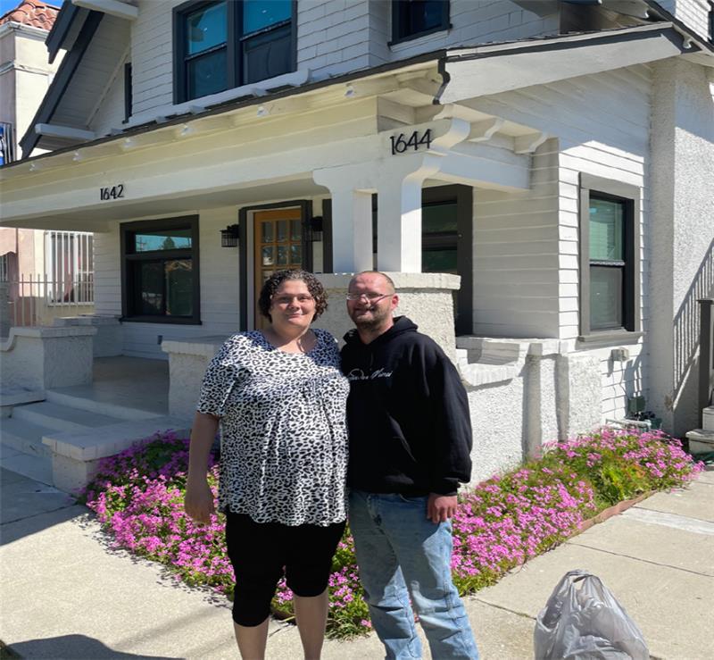 Image of a man and woman in front of a house