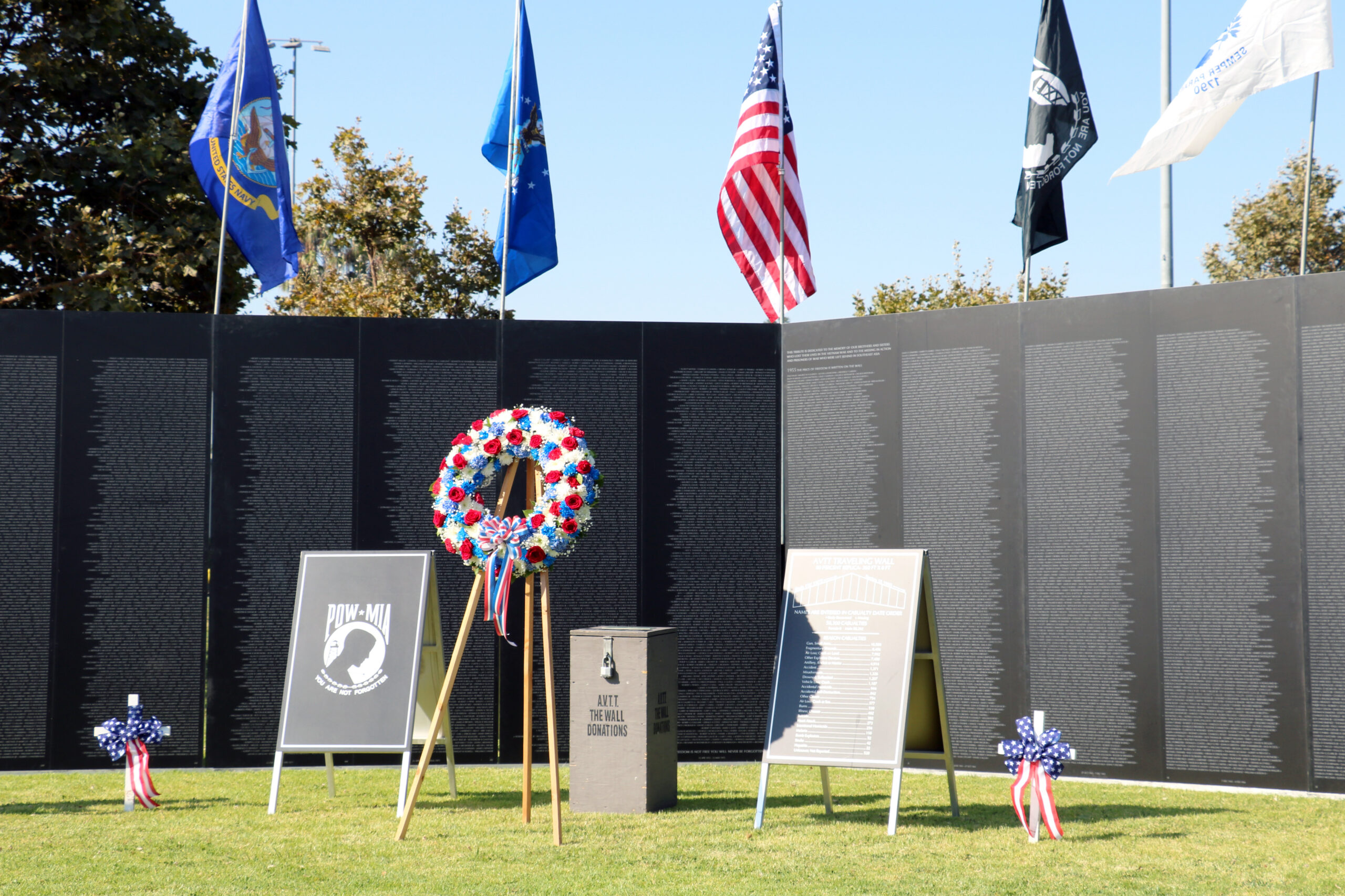 Veterans memorial wall with wreath and flags